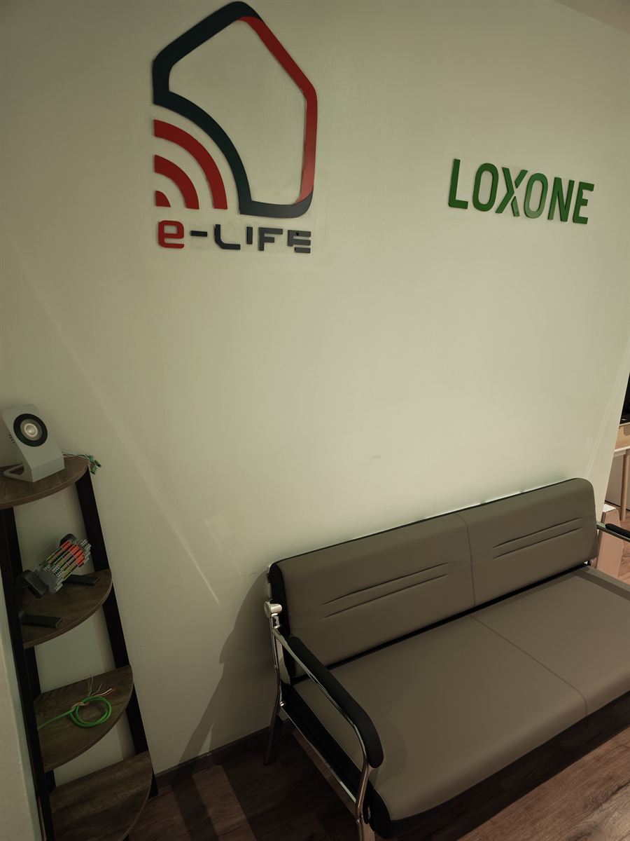Espace d'accueil du showroom avec les logos E-LIFE et Loxone